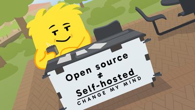 Bale, the Hay mascot, sits at a folding table holding a sign that reads 'Open source ≠ Self-hosted. Change my mind.'